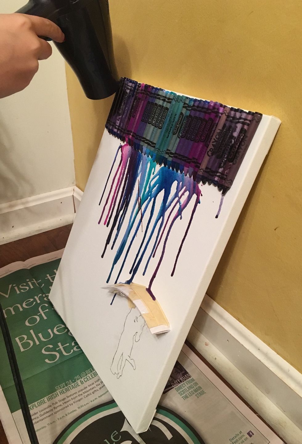 To begin, slowly move the hairdryer back and forth across the crayons and they will begin to drip down the page. In the beginning they will be more of drops, not streams, and it might take a while.