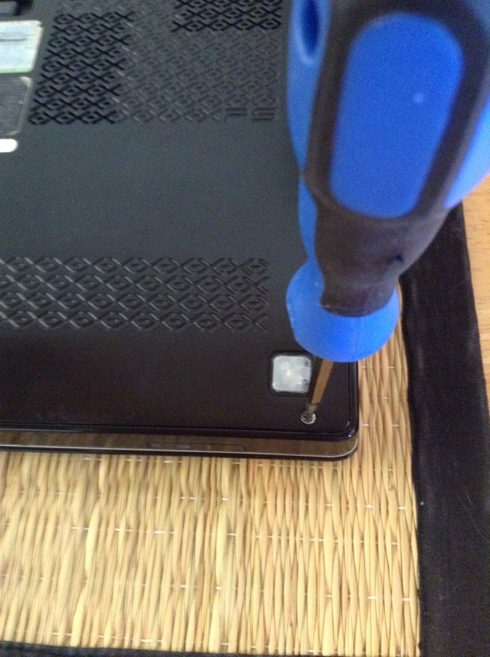 To begin, unscrew all the screws on the back of your laptop.