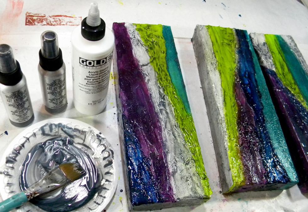 To bring out the cracks, make a glaze of Silk Tie and Raider Colorations Sprays and Acrylic Glazing Medium. Paint onto all three canvases.  After a minute, remove the excess glaze with a baby wipe.