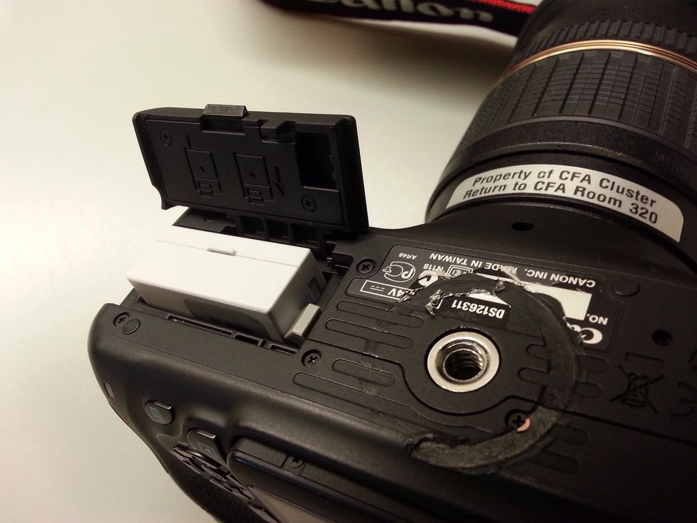 To change batteries, open the battery slot on the bottom of the camera by sliding the switch. Then slide the grey clasp to the side to eject the battery. Push the battery in to reinsert.