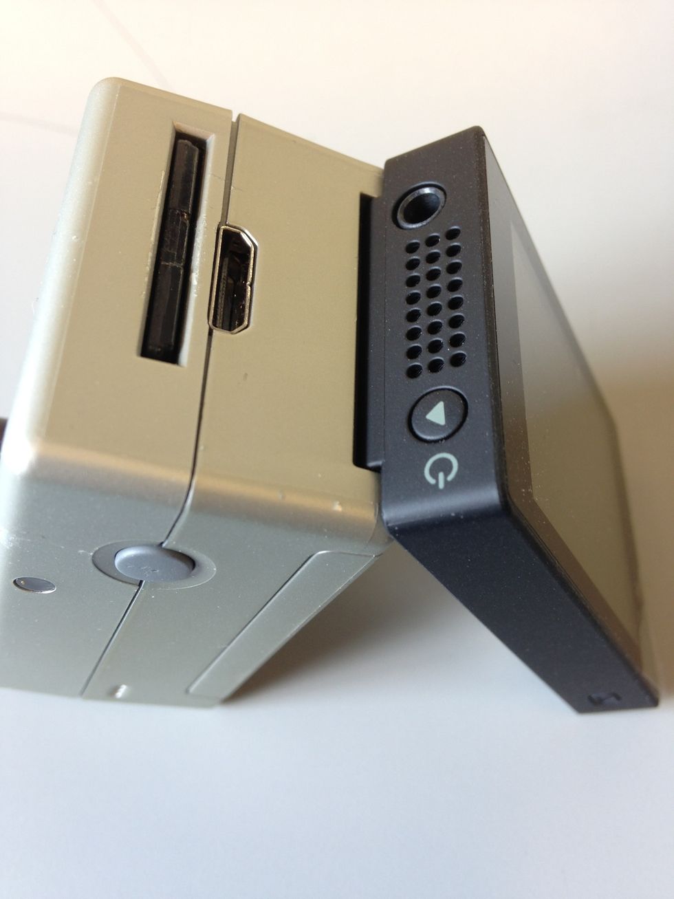 To connect the screen back to the camera, first hook the screen to the side of the camera with the SD card reader. Then, push the screen gently into the camera where you first took it apart.