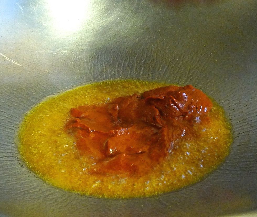 To cook the Acar, first heat up oil and put in the chili paste.