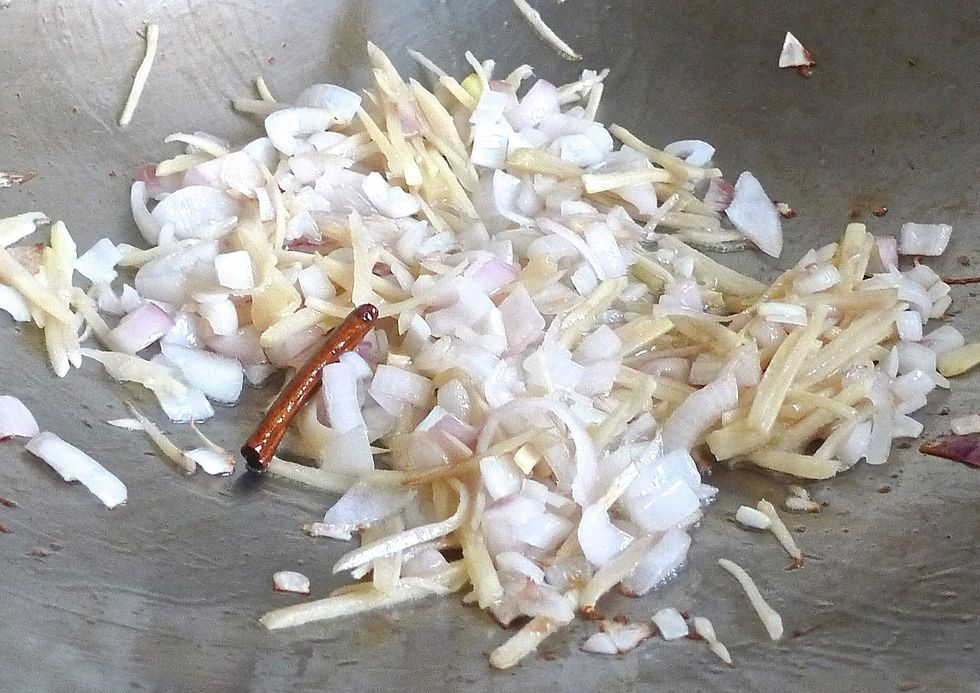 To cook the dish, first heat up oil in a wok, preferably a non-stick pan. Add cinnamon stick, ginger strips and onion cubes. Fry till fragrant.