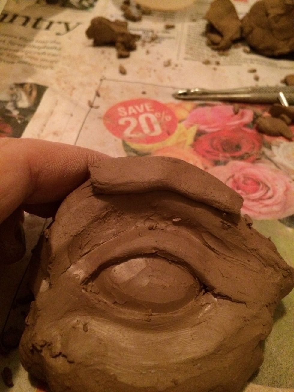 To create an eyebrow add a small amount of clay above the eye. This will be a very thin amount of clay. Don't add the clay too close to the eye.