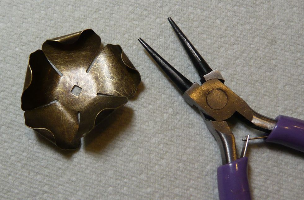 To create the flowers used on the frame, use pliers to bend the petals into the desired shape. (Flowers are from Graphic 45.)