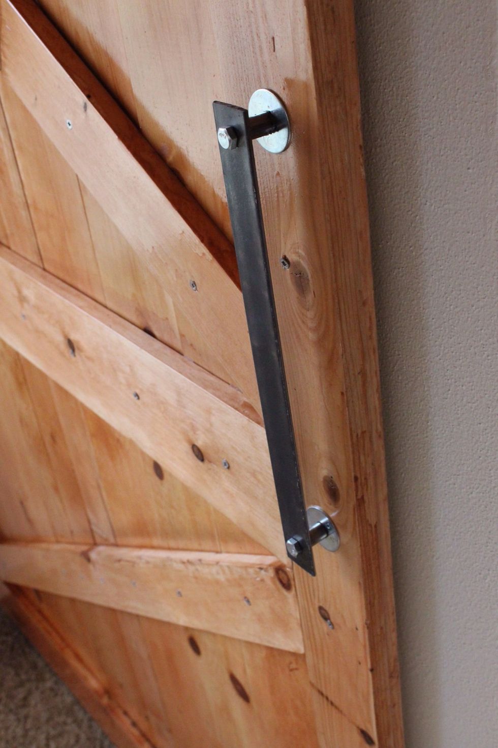 To create the handles use 1.5 inch steal. Drill 2 holes in the steal and the door, and placed a washer with a 1 inch steel pipe to extend the handle off the door. Secure with lock nuts on the rear.