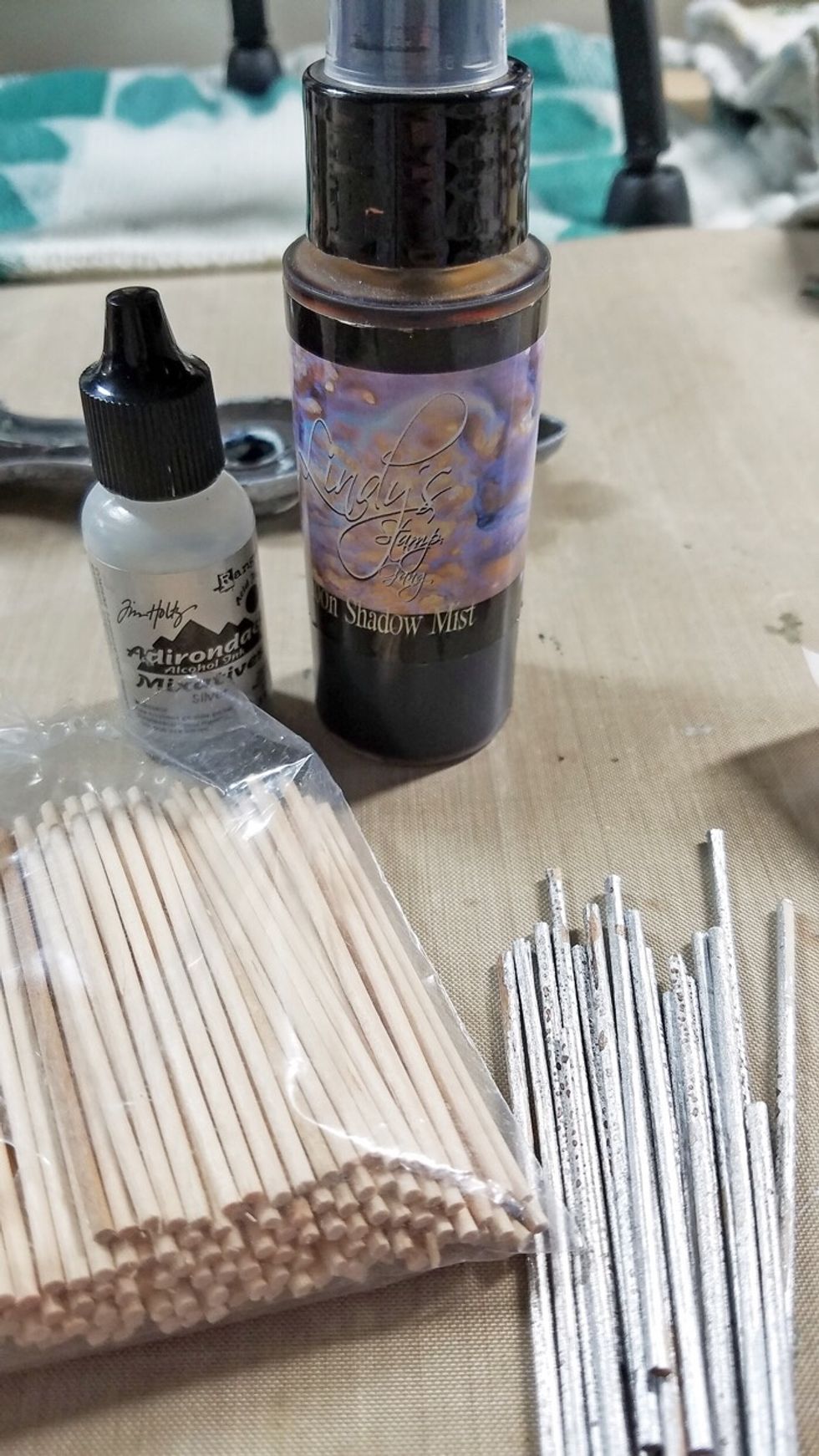 To create the \u2018sun\u2019, paint wood sticks with metallic alcohol ink and spray mist.
