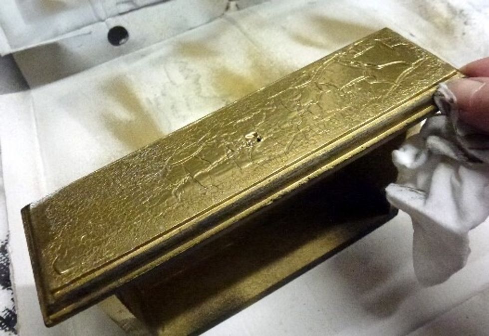 To distress use a moist baby wipe and remove gold paint along the edges of the drawers and edges of chest. Allow to dry.