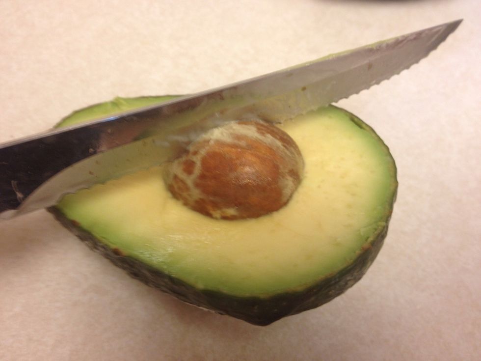 To easily remove the seed from the other half. Strike the seed sharply with your knife.