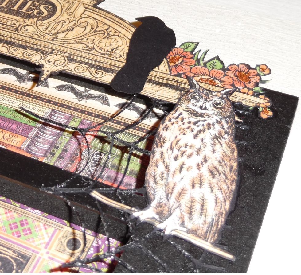 To embellish the picture frame, elements such as the owl, flowers and top and bottom borders were fussy cut from the Rare Oddities paper pack. Crows, webs & spiders were cut from card with Silhouette