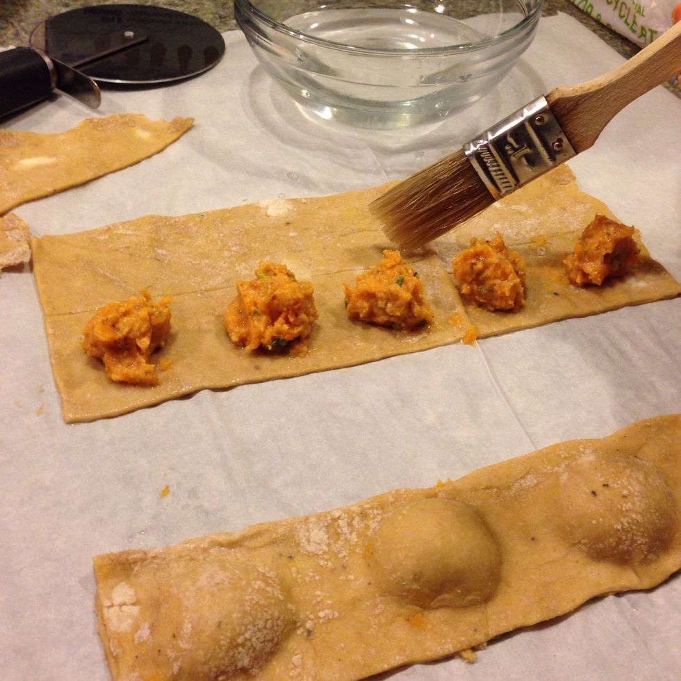 To ensure the 2 sides of pasta stick together, draw lines of water with a pastry brush to outline your squares of ravioli-to-be.