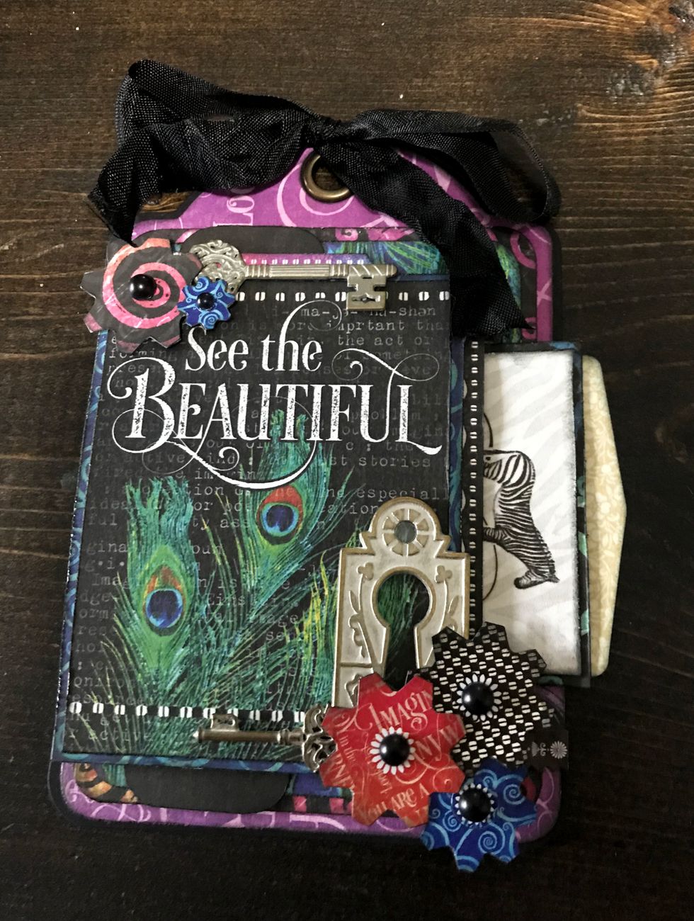 To finish off the centre of the flowers, add a black Matte Pearl Gem. To finish the tag, tie a black ribbon bow through the top of the tag.