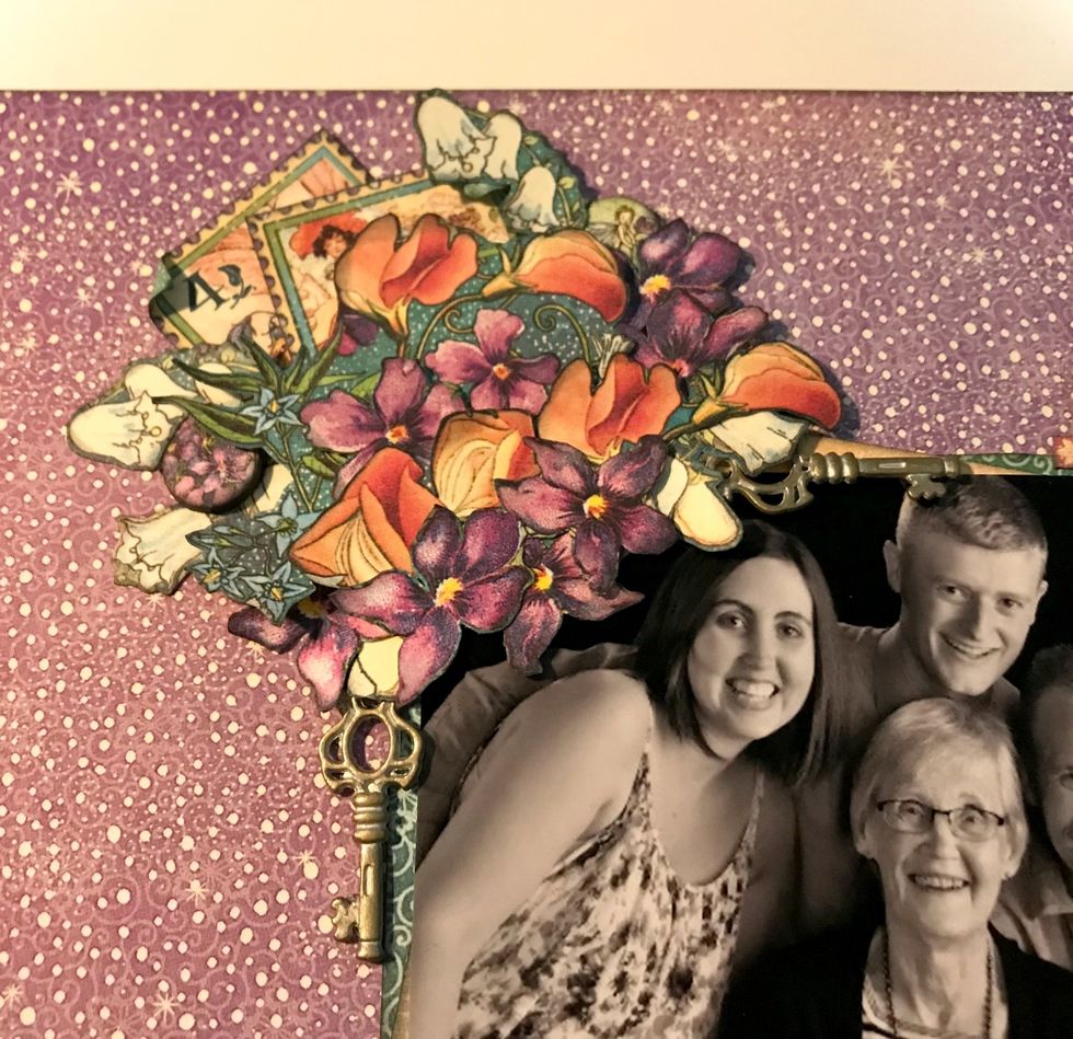 To finish off the right side of the flower bunch, adhere a shabby chic key, a chipboard circle and the rest of the single flowers in amongst the flower bunch.