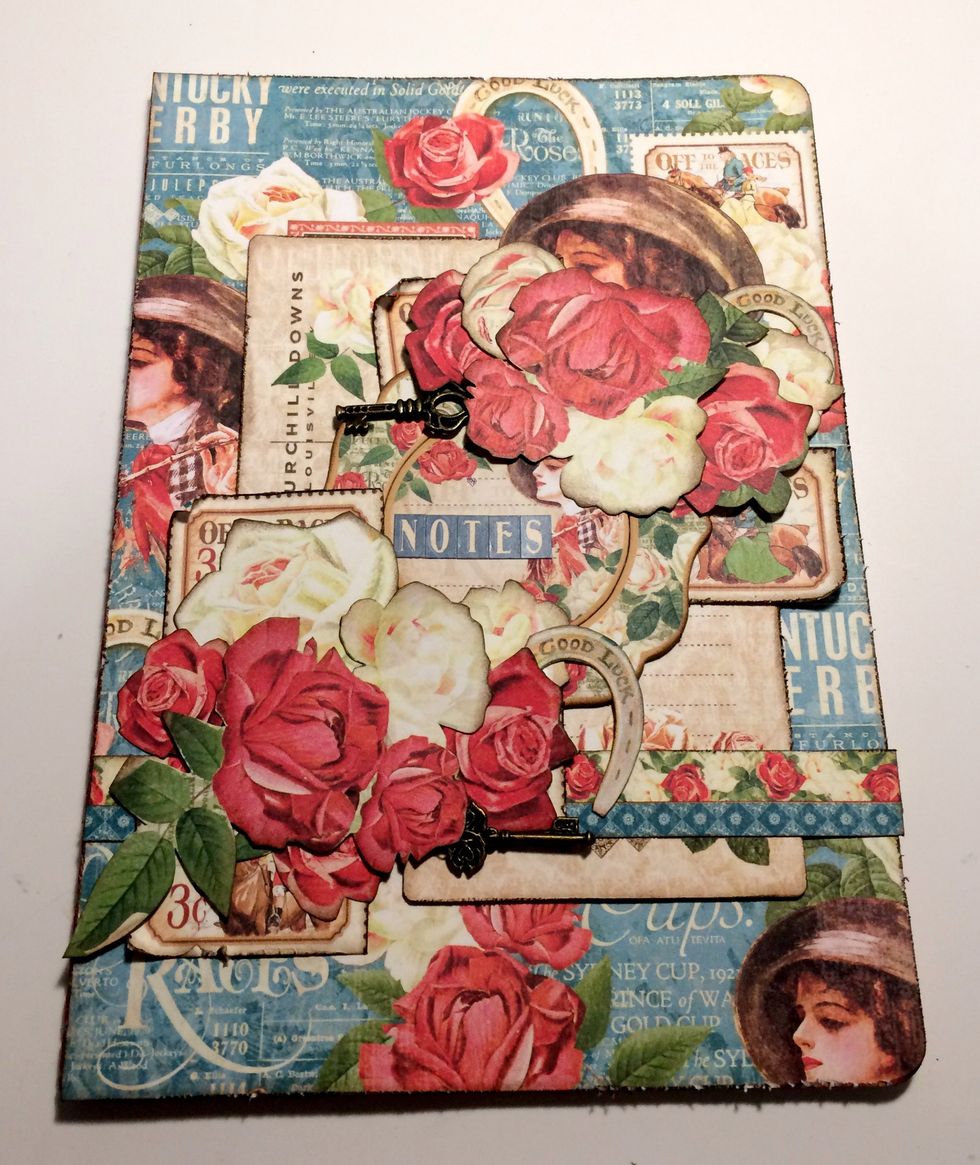 To finish the notebook, add the NOTES word to the chipboard piece in the middle of your notebook. Your second covered notebook is complete.