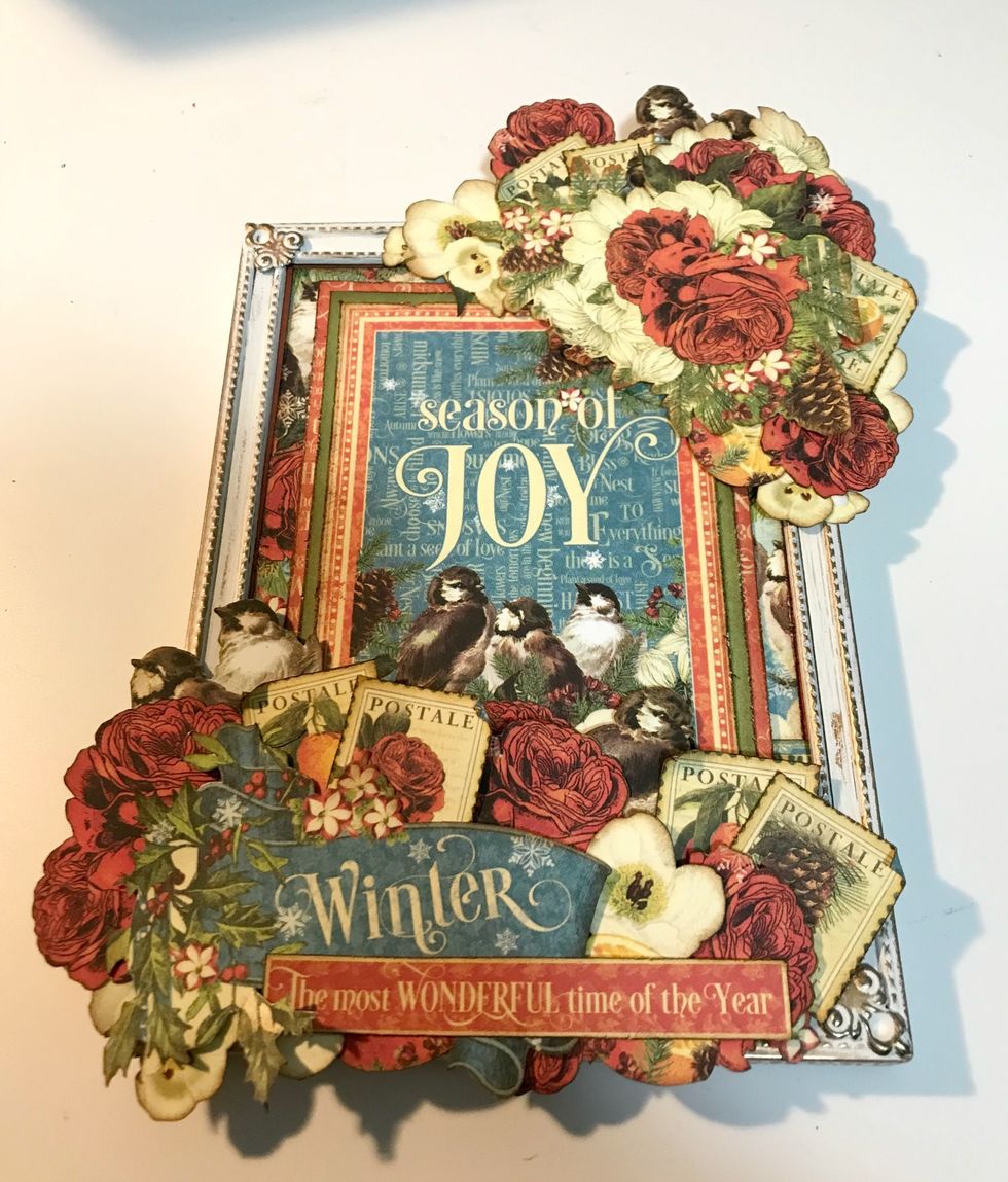 To finish your altered frame. Add a green photo corner in the top left hand corner of the Season of Joy Card. Your Season of Joy Altered Frame is finished!