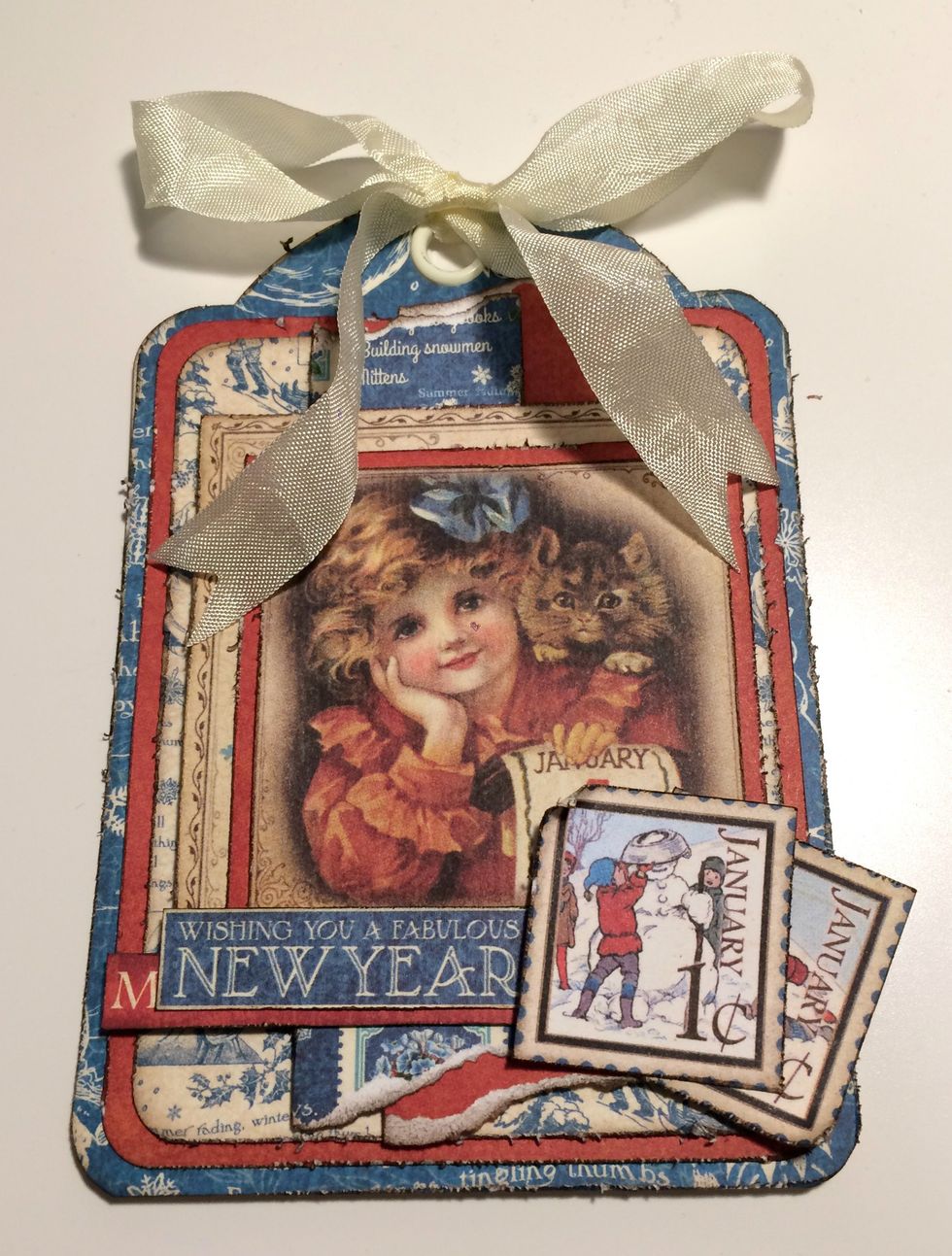 To finish your first winter tag, add a cream bow at the top of the tag. Your first winter tag is now complete.