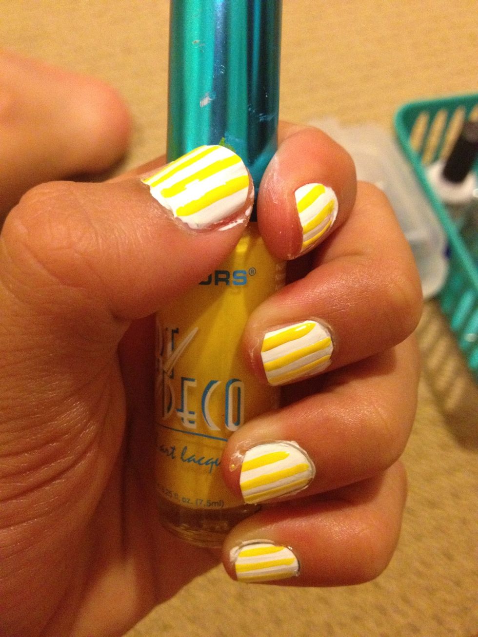 To give your nails a background, take your yellow thin brush nail polish and slowly draw a vertical line