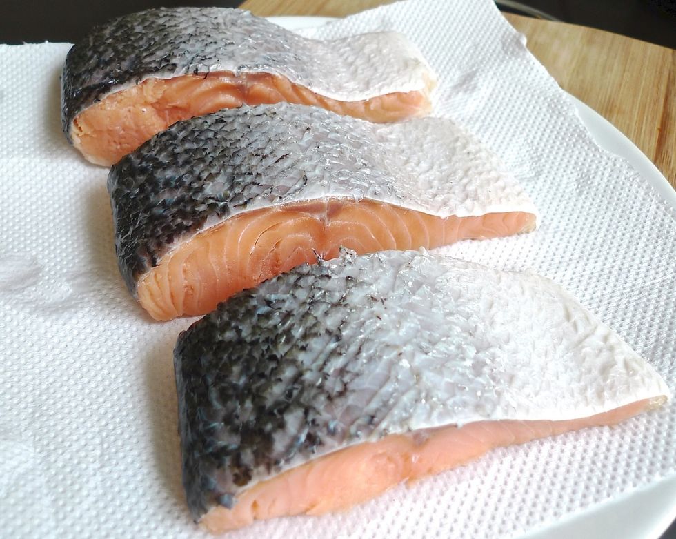 To grill salmon, first rinse the serving-size fillets under cold water and pat dry with paper towels. Pull out any obvious bones.