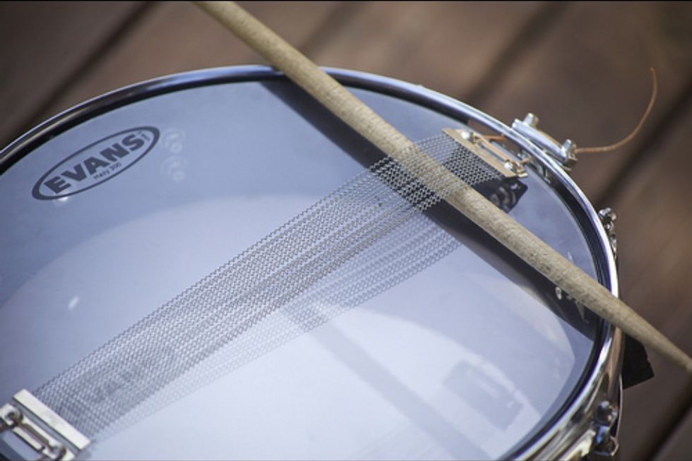 To hear the bottom head more clearly, use a stick to hold the snares up. This step can be skipped. It's just to hear more clearly.