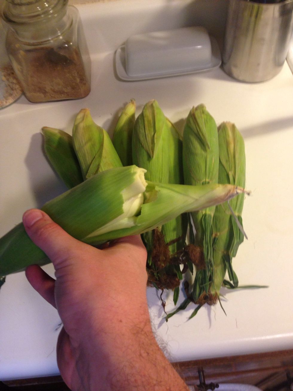 To husk your corn, first break the stem. Then pull away whatever husk leaves come with it.