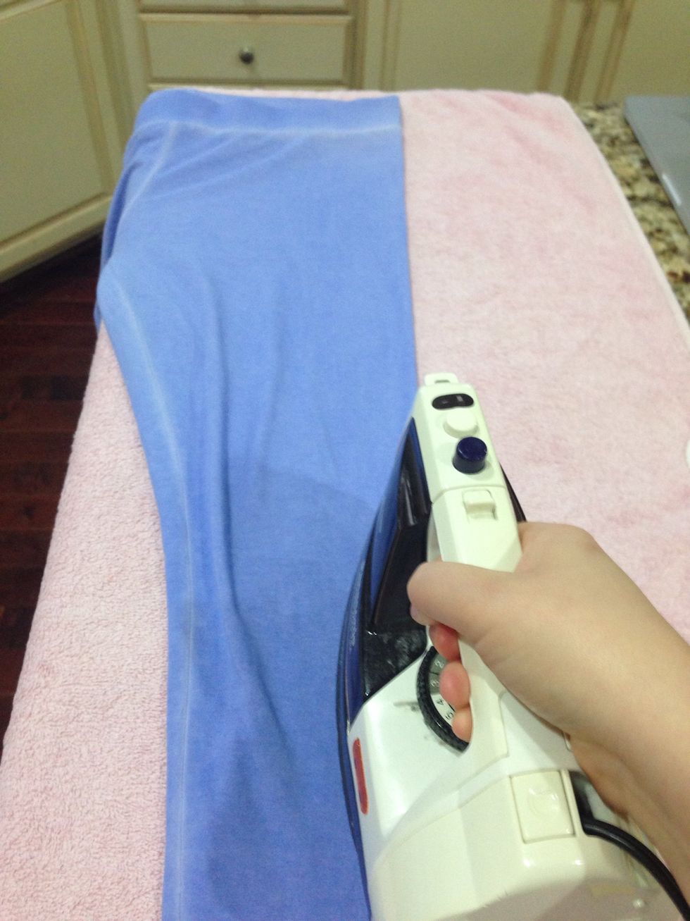 To identify the middle you can lay out the pants and iron the edge. Once you are done ironing the edge you will see a crease that will help you when you fuse the ribbon onto the pants.