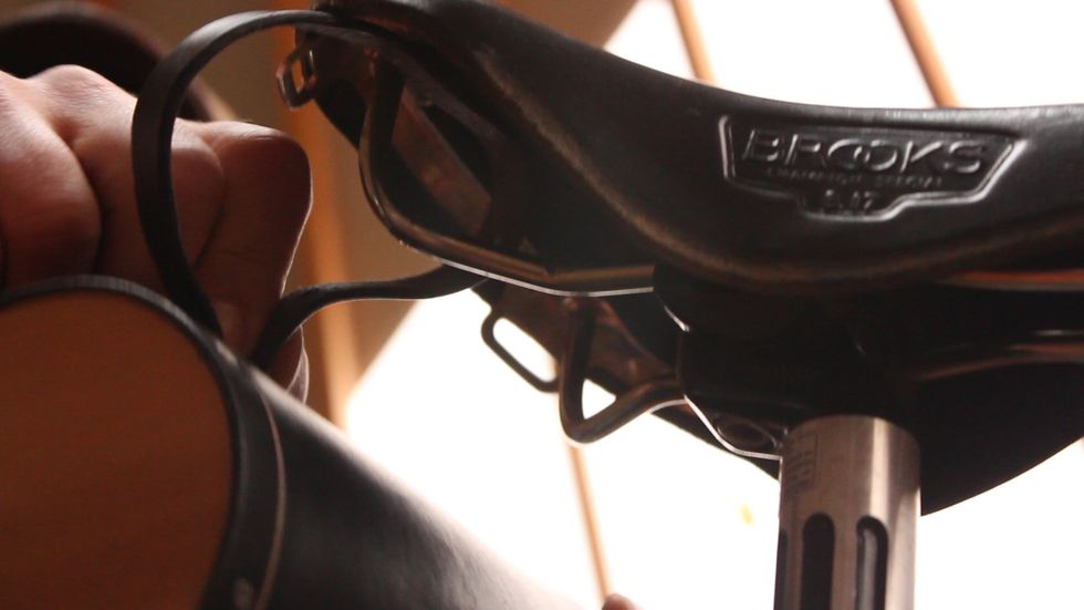 To install on the seat rails, weave the belt from the outside in around the right seat rail.