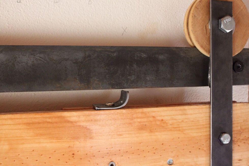 To keep the door always on its track cut a piece of left over steel to act as a guard at the top of the door. There should be one on ends of the door.
