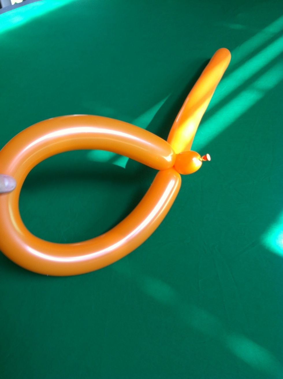To make a basic hat first twist a small bubble and a loop large enough to fit the head.