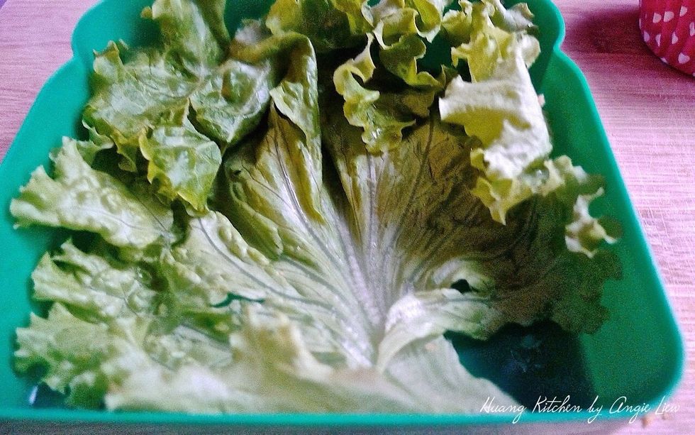 To make a creative lunchbox with these crispy fish cocktails, first lined the lunchbox with some fresh lettuce.