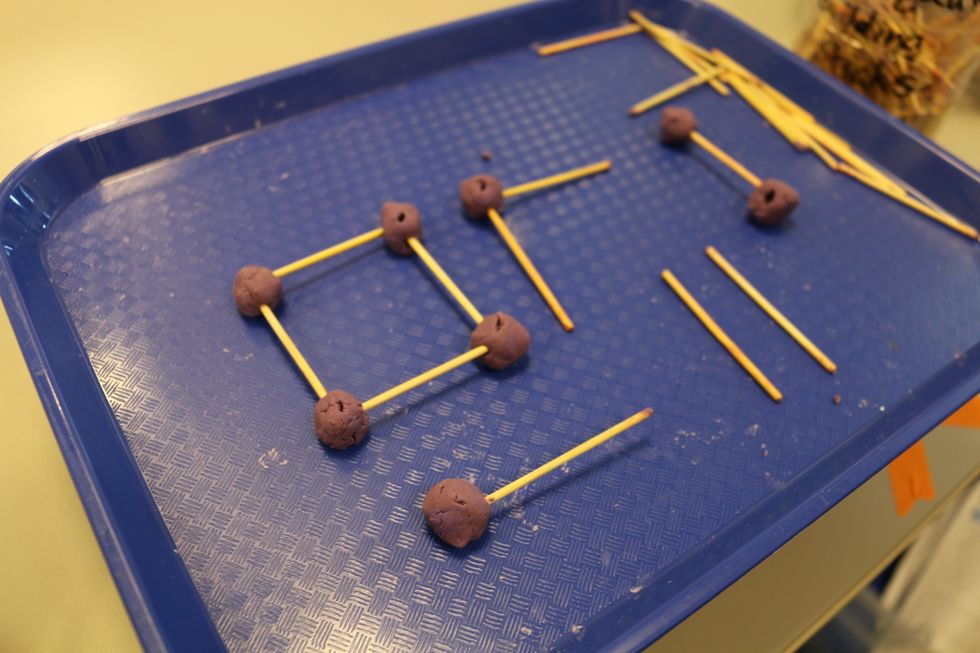 To make a structure, we make small balls using play-dough and attach them to the end of a stick. The play-dough balls act as joints for our structure. It allows us to make different shapes.