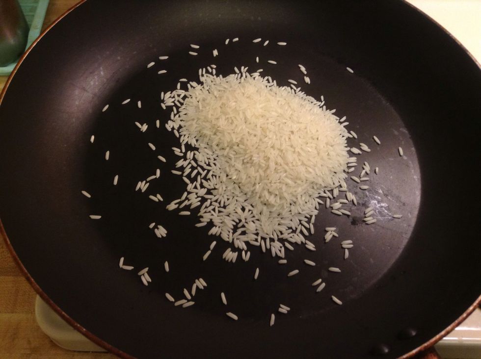 To make dried rice powder, take some raw rice and roast in a pan until golden browned.
