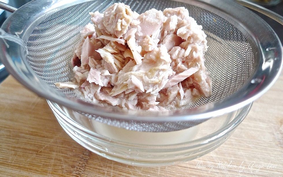 To make potato tuna salad, first drain the white tuna.