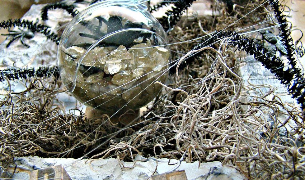 To make spider webs, take your hot glue gun and drizzles the strings from the hot glue across your project.