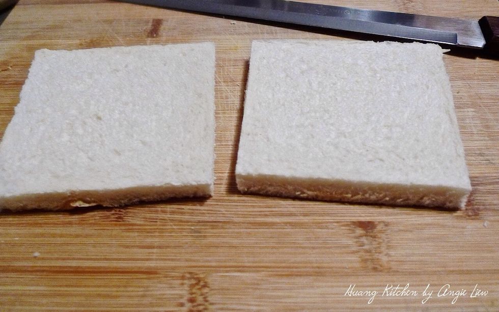 To make the banana rolls, first cut the crust off on all sides of two white sandwich bread
