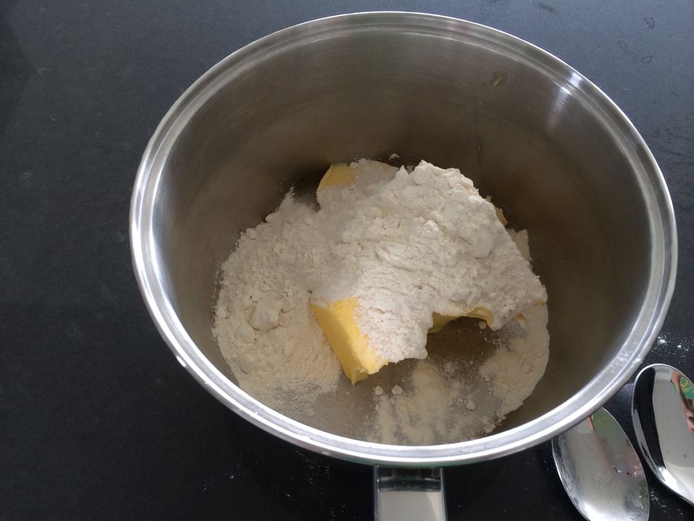 To make the creamy sauce add the flour and butter to a saucepan. Have the stove top on medium heat and combine the flour and butter.