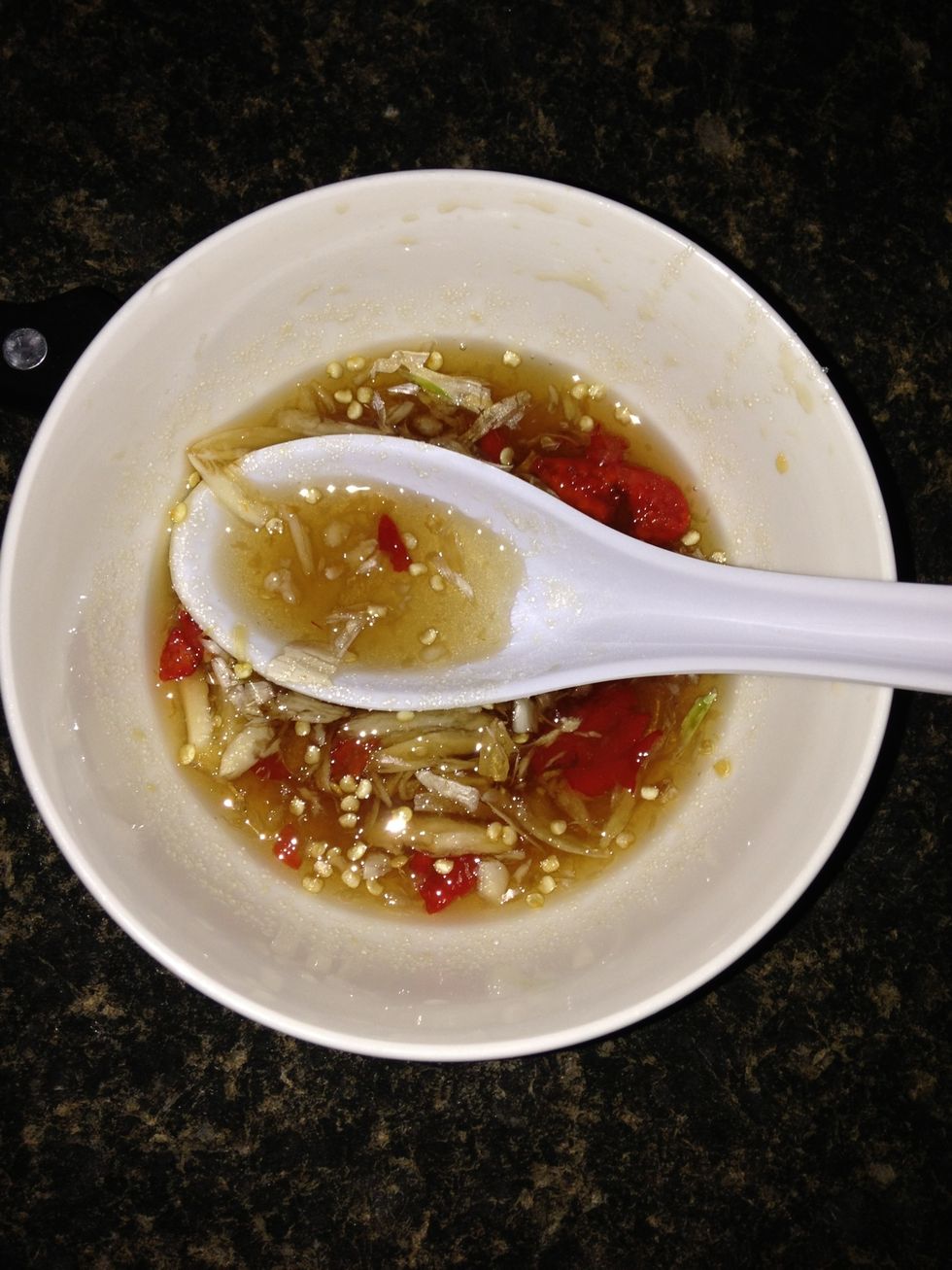 To make the sauce: Add the smashed up garlic and red pepper into fish sauce and sugar