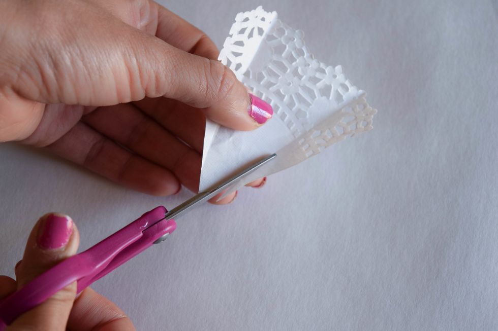 To make the top of your dress, draw lines with pencil or fold the smaller piece of doily inward and cut along the designated lines.