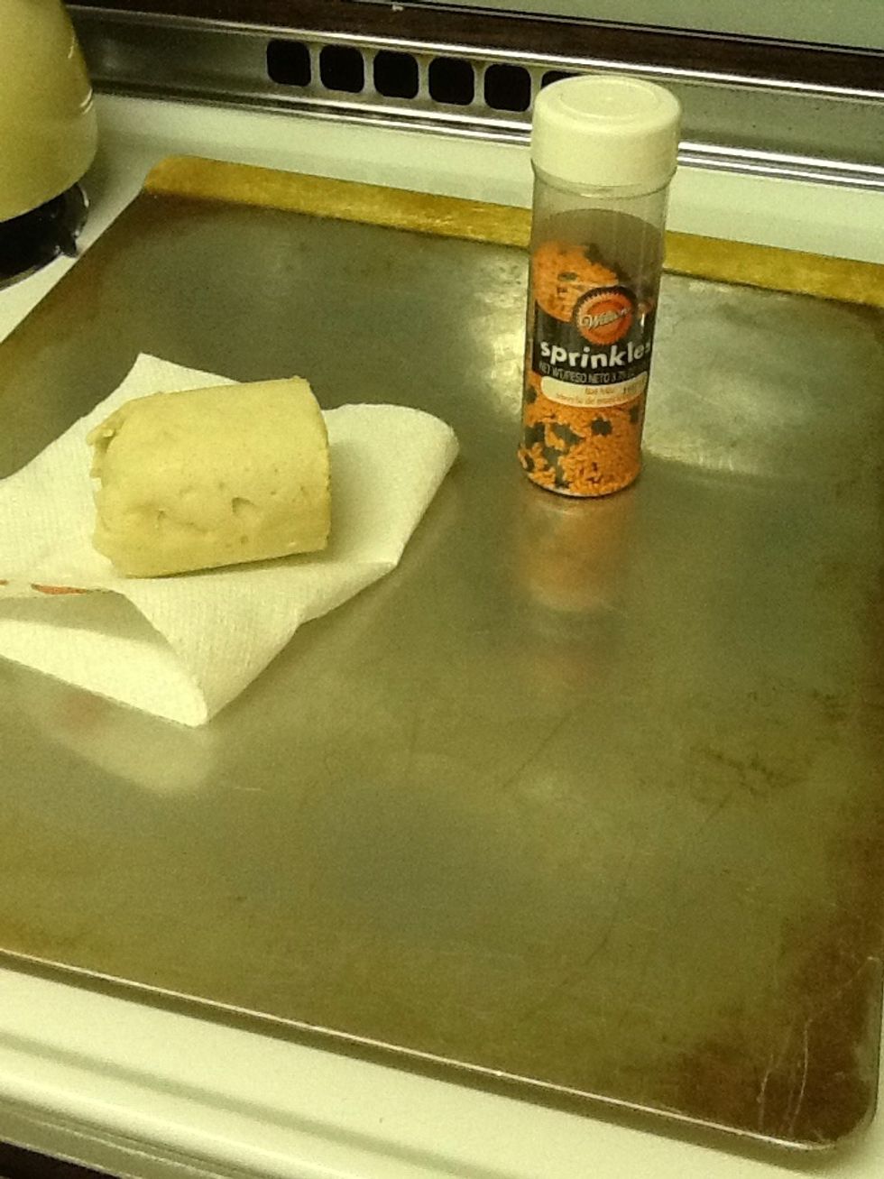 To make these sprinkle cookies you need a cookie pan and cookie dough, which can be homemade, or in my case store bought. Also you need sprinkles, and I am using black and orange ones for Halloween.