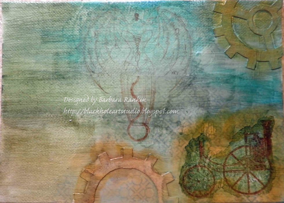 To prevent color migration, spray canvas with Krylon Workable Fixatif, let dry. Then adhere Sin City Stamps winged dress form with matte medium. See the difference between the two images?