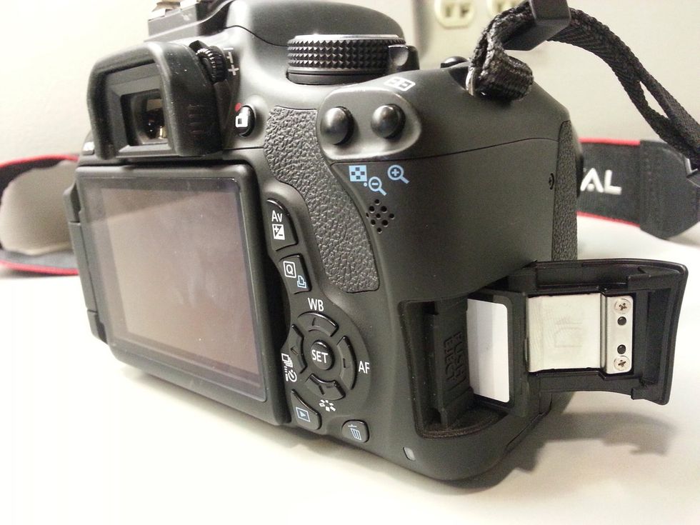 To remove the memory card, open the card slot on the right side of the camera by sliding it out. Then press the card in to eject. Be sure to reinsert the card correctly.