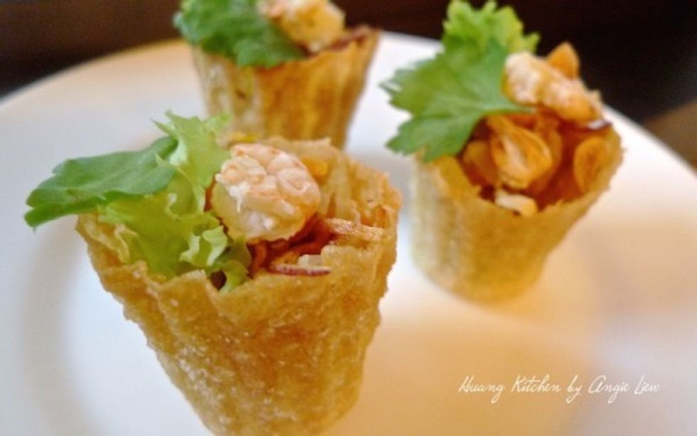 To serve, fill the pie tee shells with savory turnip filling and then top with cooked prawn, shallot crisps, coriander leaves and chilli sauce.