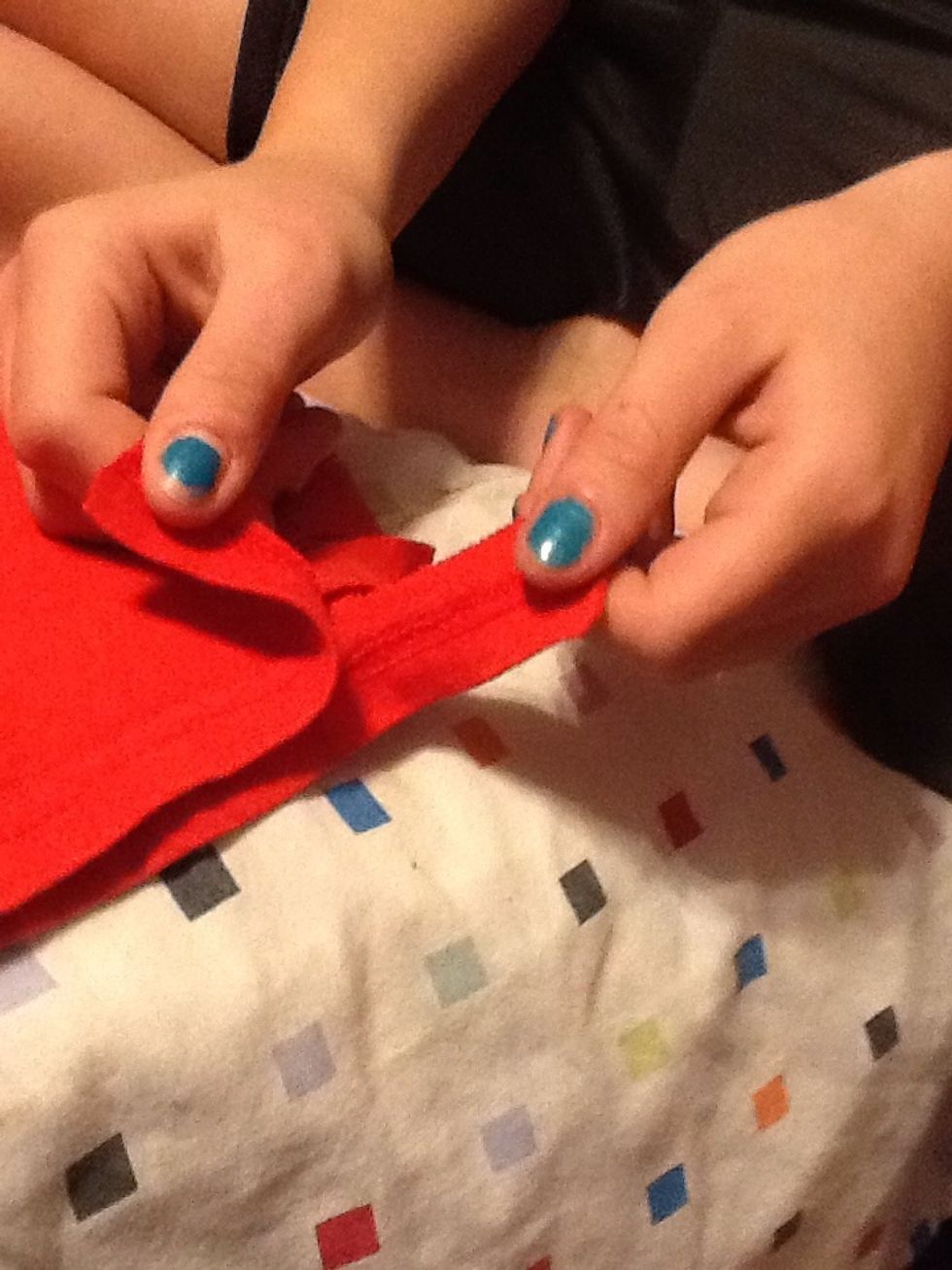 To start tying the tabs, take the first pair and separate them into each hand.