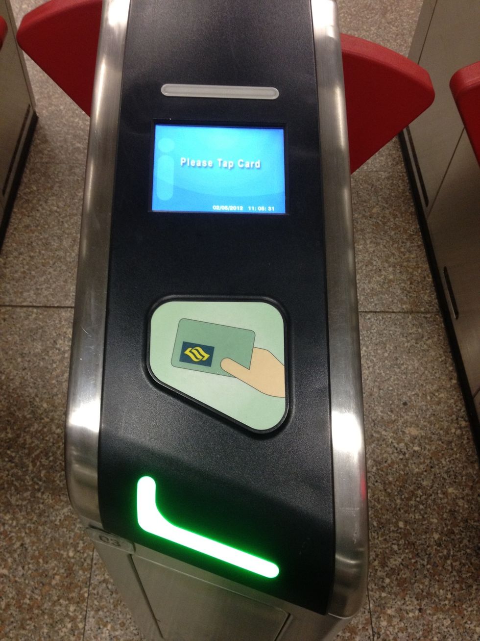 To tap, gently put your card on the green area with the image of a hand holding a card. A green light will flash and the gate will open. The small screen above will then show the balance of your card