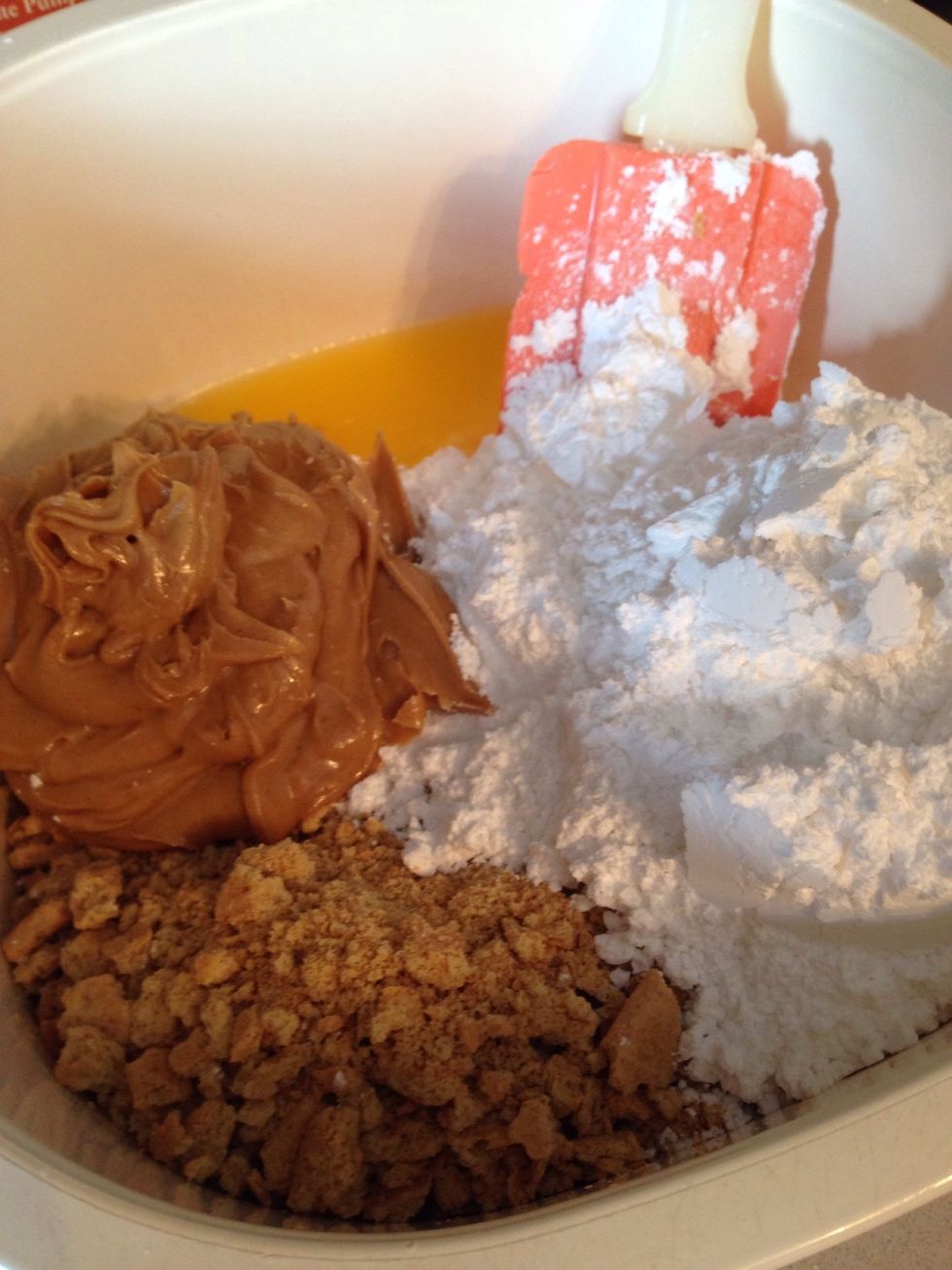 To the melted butter, add the graham crackers, peanut butter, and powdered sugar