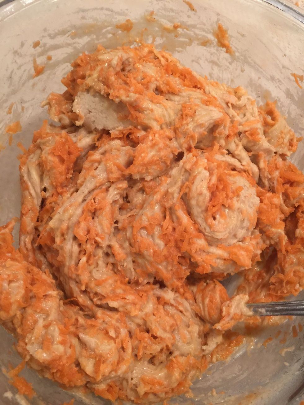 To the mixing bowl add shredded carrots, nutmeg and cinnamon.