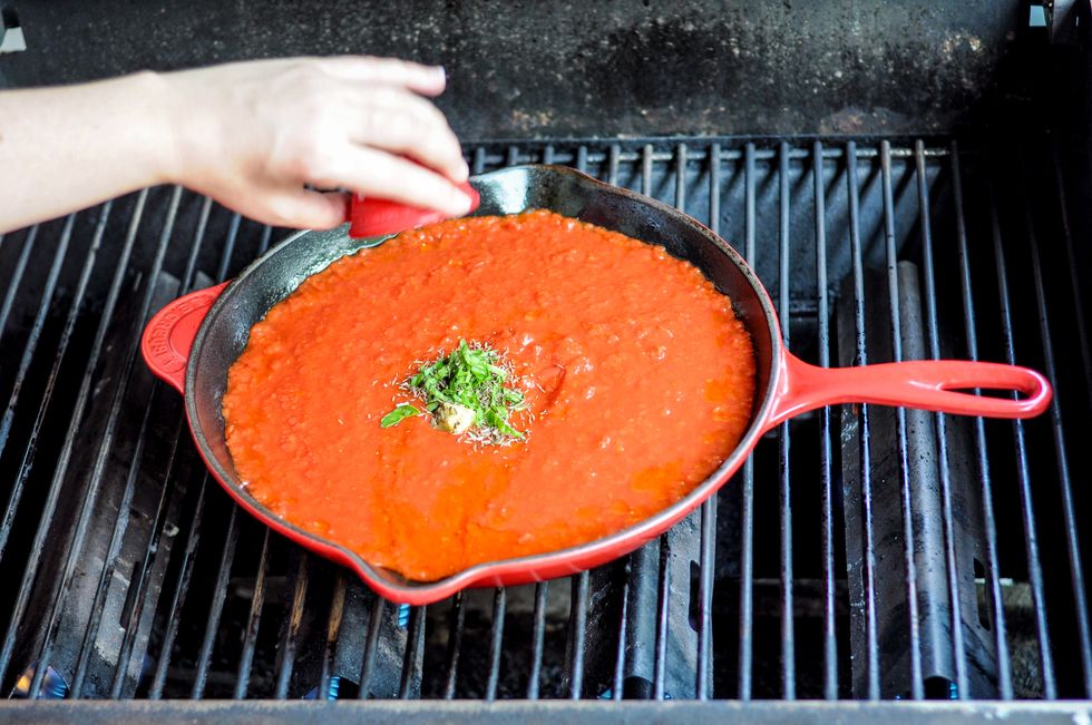 To the skillet, add crushed tomatoes, oil, garlic, basil, thyme, rosemary, salt and pepper. Stir to combine.