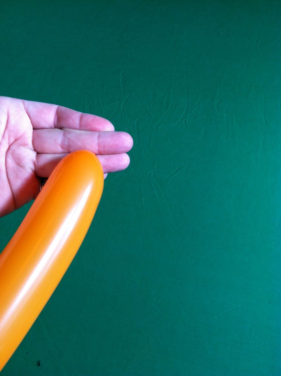 To tie, lay across your palm and bring nozzle of balloon between your middle and ring fingers (towards back of hand)