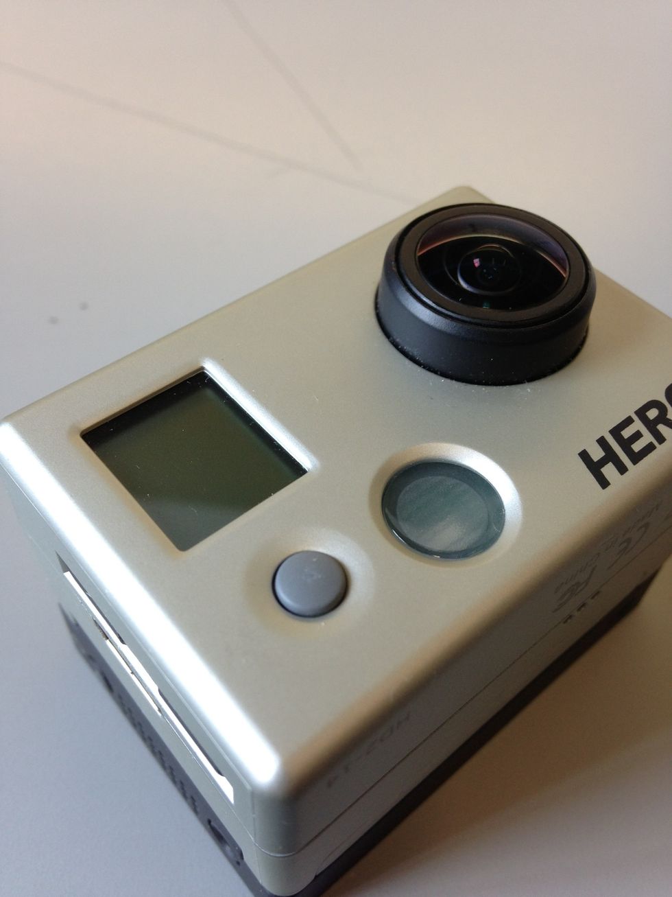 To turn on the camera, press and hold the Mode button to the left of the lens. Use the Mode button to swap different modes.