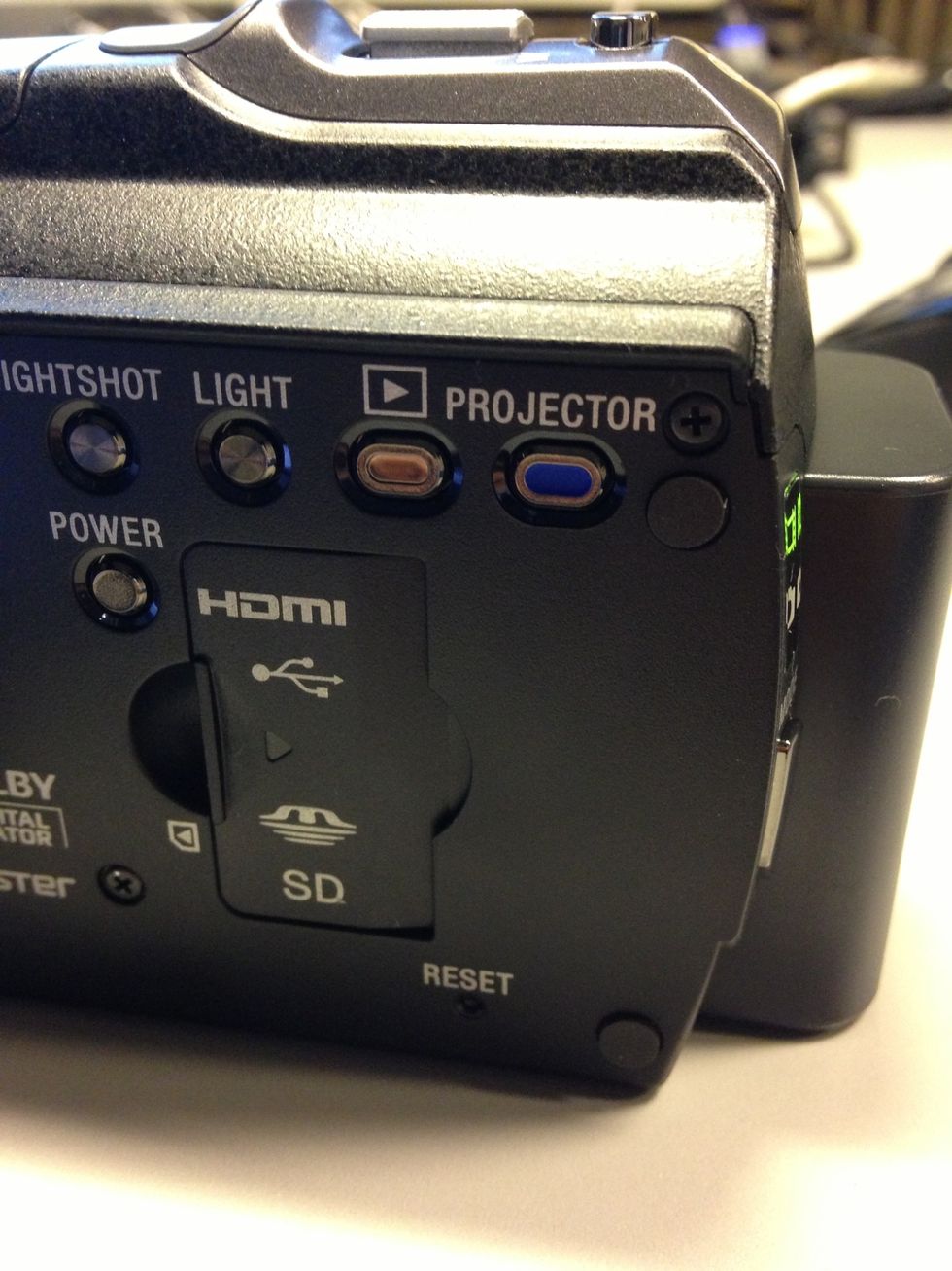 To view your videos, press the Review button on the side of the camera. Tip: this camera is also equipped with a projector. Press the Project button to begin projection.