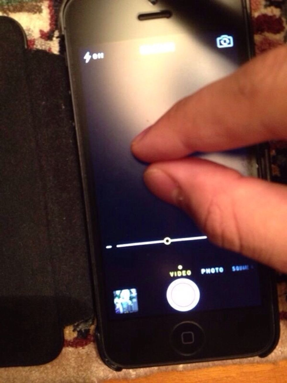 To zoom in the photo/video mode,you need to pinch the screen with two fingers,then continue to pinch either in or out to decrease or increase zoom. Or use the slider as in the picture above to +/-.